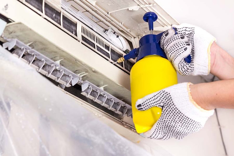 Air-Ton Heating & AC technician performing HVAC maintenance on a ductless mini split in Houston, Texas.