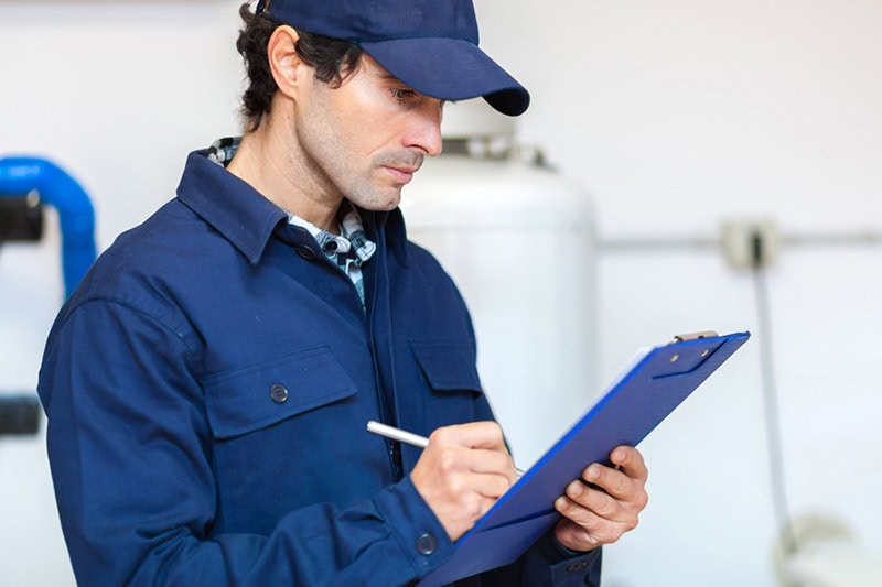 Air-Ton Heating & AC technician looking over his furnace maintenance checklist.