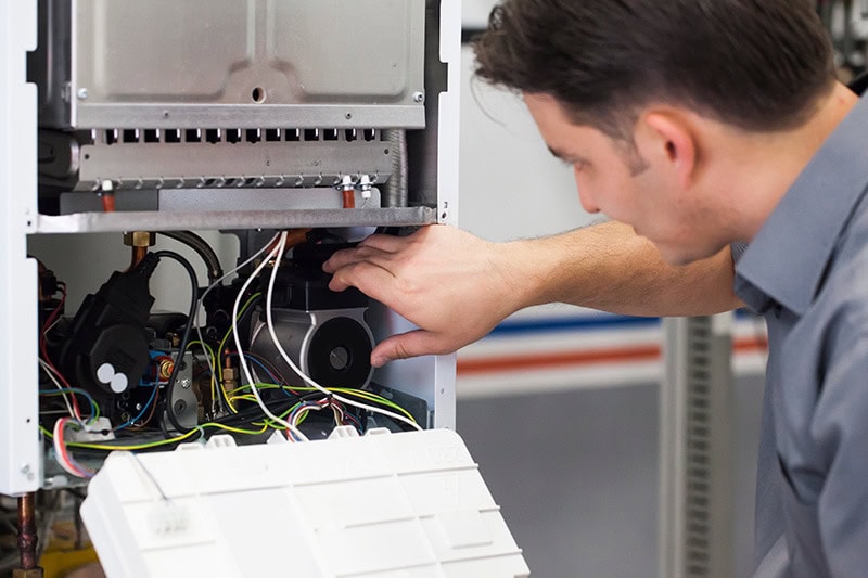 Technician performing annual HVAC maintenance for homeowner
